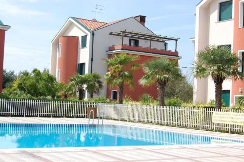 um edifício com piscina em frente a um edifício em Residence Ca' D'Oro em Cavallino-Treporti