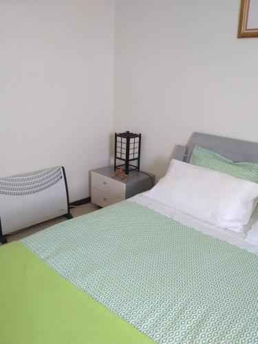 a bedroom with a bed with a green rug at Rua 5 House in Gafanha da Vagueira