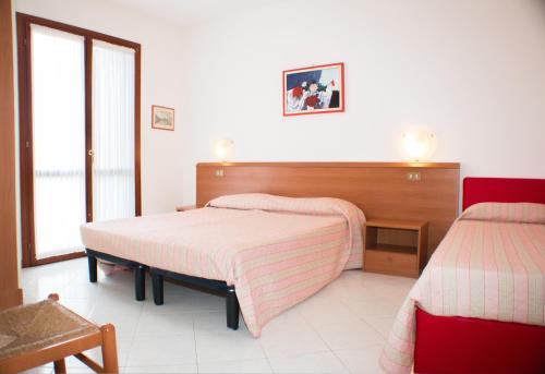 a bedroom with two beds with pink blankets on them at Residence Ca' D'Oro in Cavallino-Treporti