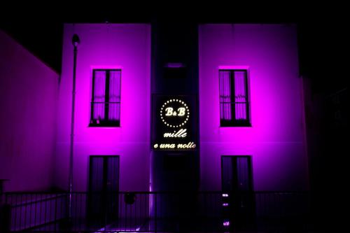 a building with pink lights on the side of it at Mille e Una Notte in Nuova Gibellina
