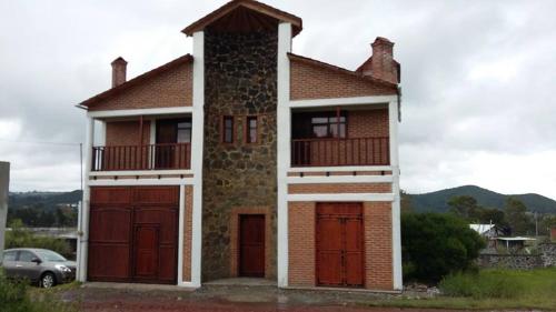 una casa con dos puertas de garaje y un coche en Hospedaje Herradura en San Miguel Regla