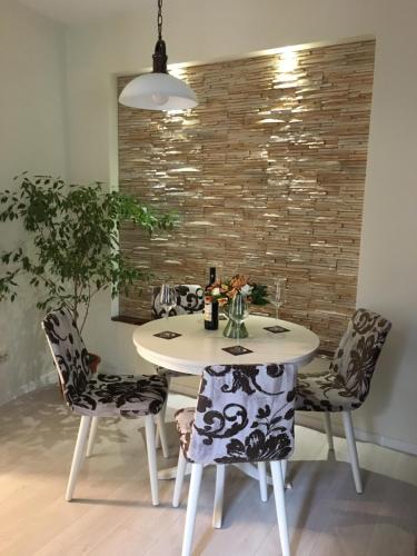 a dining room table with chairs and a white table at Poarta Ecaterina Residence in Braşov