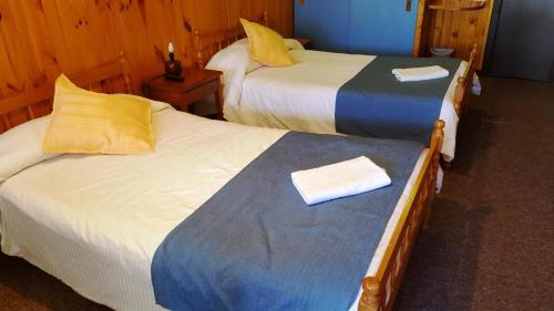 two beds sitting next to each other in a room at Hostal Vista al Mar hct in Ancud