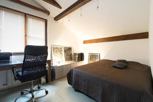 a bedroom with a bed and a desk and a chair at Old Town Apartment in Sarajevo
