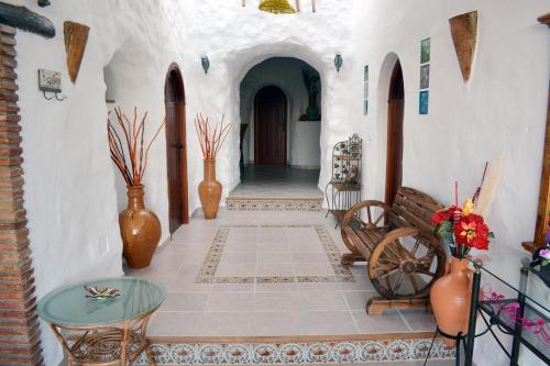 a hallway of a building with a table and vases at Casas Cueva con piscina y barbacoa in Fontanar