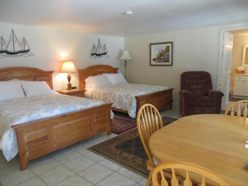 Habitación de hotel con 2 camas y mesa en Caprice, en Gibsons