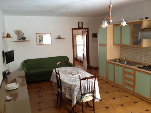 cocina con mesa y cocina pequeña con sofá en Casa al Mare en Buggerru
