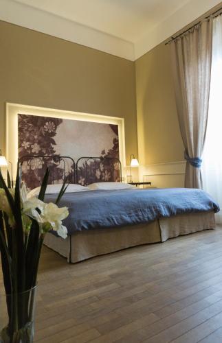 a bedroom with a bed with a painting on the wall at Locanda di Pietracupa in Tavarnelle in Val di Pesa