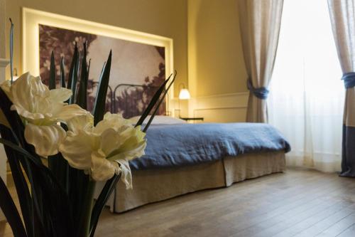 a bedroom with a bed and a vase with flowers at Locanda di Pietracupa in Tavarnelle in Val di Pesa