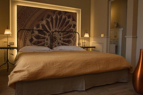 a bedroom with a large bed with a large headboard at Locanda di Pietracupa in Tavarnelle in Val di Pesa
