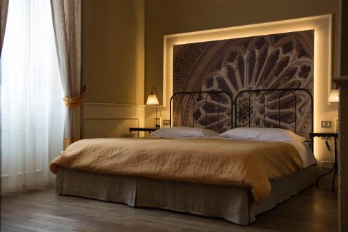 a bedroom with a bed with a large headboard at Locanda di Pietracupa in Tavarnelle in Val di Pesa