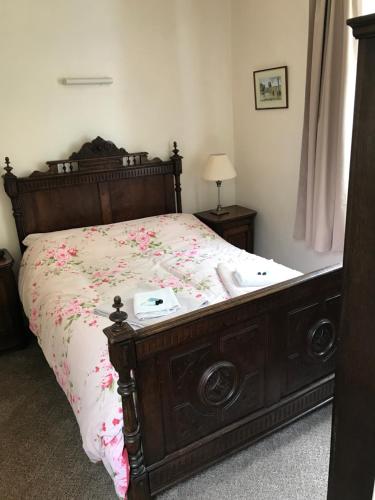 ミラーズ・デールにあるAnglers restのベッドルーム1室(花の飾られた木製ベッド1台付)