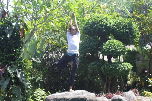 a man is doing yoga on a rock at Baruna Sari Villa in Ubud