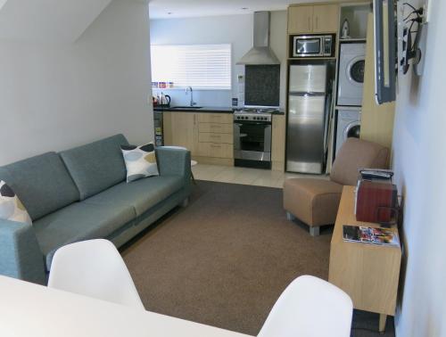 ein Wohnzimmer mit einem Sofa und einer Küche in der Unterkunft Merivale Apartments in Christchurch