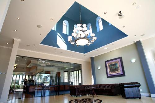 a large lobby with a blue ceiling with a chandelier at Shangri-La Gardens in Brisbane