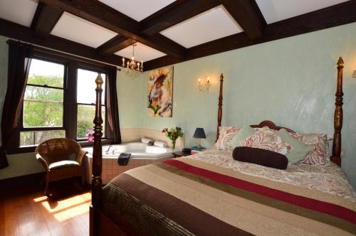a bedroom with a bed and a tub and a window at Marketa's Bed and Breakfast in Victoria