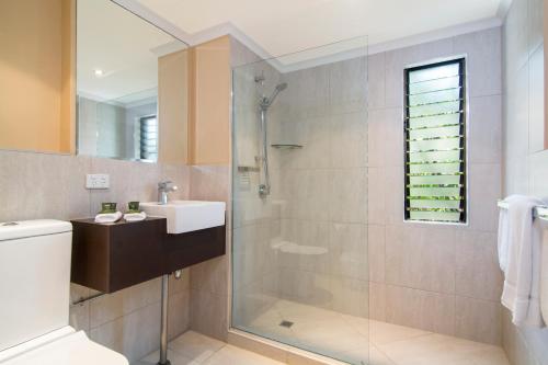 a bathroom with a shower and a sink at Villa San Michele (Official) in Port Douglas