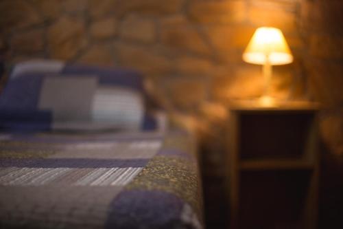 a lamp sitting on a table next to a bed at Carü Leufu in Valle Grande