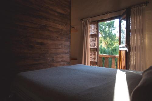 a bedroom with a bed and a window at Carü Leufu in Valle Grande