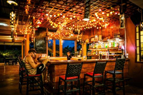 Ein Mann sitzt in einer Bar in einem Restaurant. in der Unterkunft Villa Vedici in Kampot