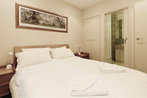 a bedroom with a white bed and a glass door at Alto Villa 301 in Mount Buller