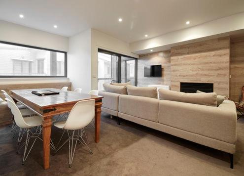 Una sala de estar con un sofá grande y una mesa. en Alto Villa 304 AMS Mt Buller, en Mount Buller