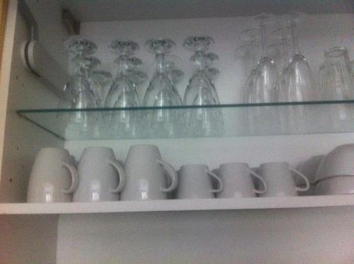 a bunch of glass vases and cups on a shelf at Appartement Le Jardin in Lingolsheim