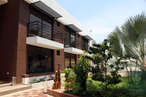 a building with a palm tree in front of it at Hotel Restaurante Versalles in Melgar
