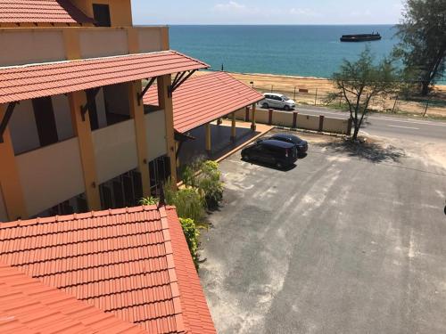 a car parked in a parking lot next to a building at Teluk Lipat Seaview Inn in Dungun
