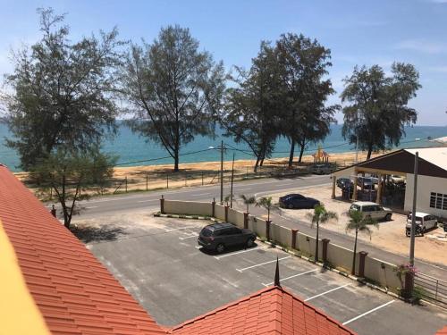 a parking lot with cars parked in front of the ocean at Teluk Lipat Seaview Inn in Dungun