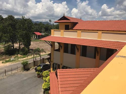 a building with a red roof and a parking lot at Teluk Lipat Seaview Inn in Dungun