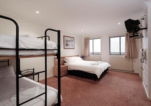 a bedroom with two bunk beds and two windows at Enzian 318 in Mount Buller