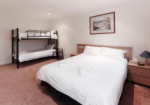a bedroom with a bed and two bunk beds at Enzian 318 in Mount Buller