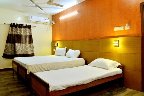 a room with two beds in a room at Hotel Ganga Tamilnadu in Nāgercoil