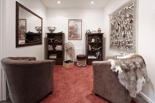 a living room with two chairs and a mirror at Apartment K2 07 in Mount Buller