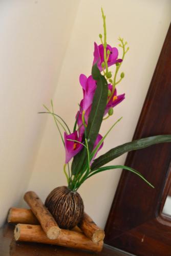 a vase of flowers on a table with cinnamon sticks at Anon Rest in Dambulla