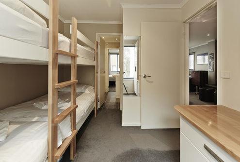 a room with two bunk beds and a kitchen at Valley View 203 in Mount Buller