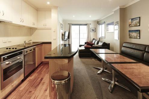 a kitchen and living room with a table and a couch at Valley View 203 in Mount Buller