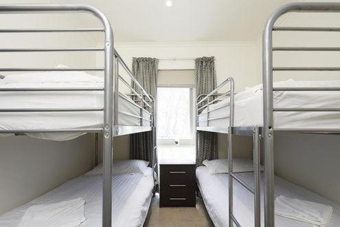 two bunk beds in a room with a window at Whistler 2 in Mount Buller
