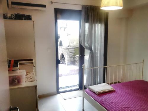 a kitchen with a door to a window with a table at Luxury apartment by the beach in Néa Péramos