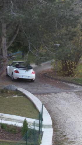 a white car driving down a road with a roof at Affittacamere Rubino Guest House in Ponte nellʼAlpi