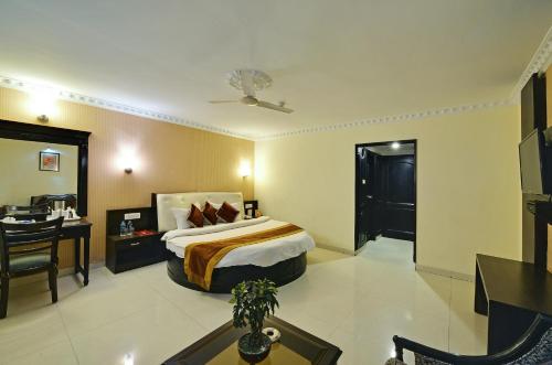 a hotel room with a bed and a table and a desk at Hotel City Heart Premium in Chandīgarh