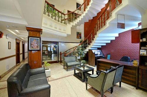 a lobby with a couch and chairs and stairs at Hotel City Heart Premium in Chandīgarh