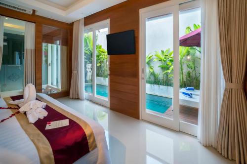 a bedroom with a bed and a view of a pool at Sithala Villa Seminyak in Seminyak