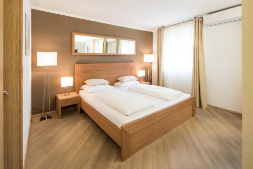 a bedroom with a bed and a mirror on the wall at Boutique Hotel Zum Rosenbaum in Nalles
