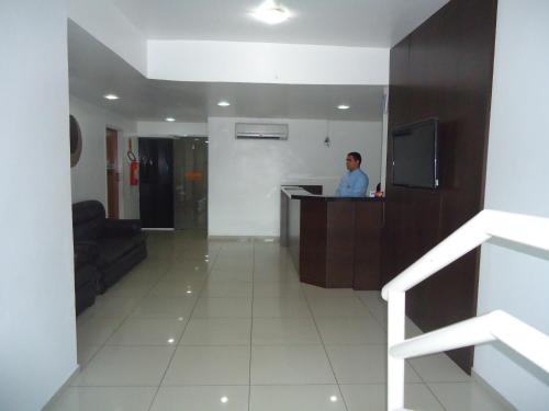 a man standing at a counter in a room at Hotel Pio in Teresina