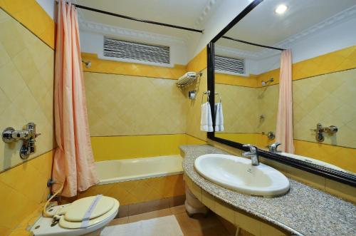 e bagno con lavandino, servizi igienici e vasca. di Hotel City Heart Premium a Chandīgarh