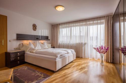 a bedroom with a large bed and a large window at Appartements Schwaighofer in Kössen