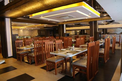 a dining room with wooden tables and chairs at The Curzon Court in Bengaluru