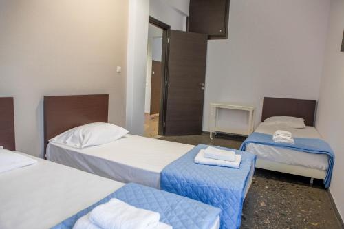a hotel room with two beds and a door at Lak Alepochori Homes in Káto Alepokhórion